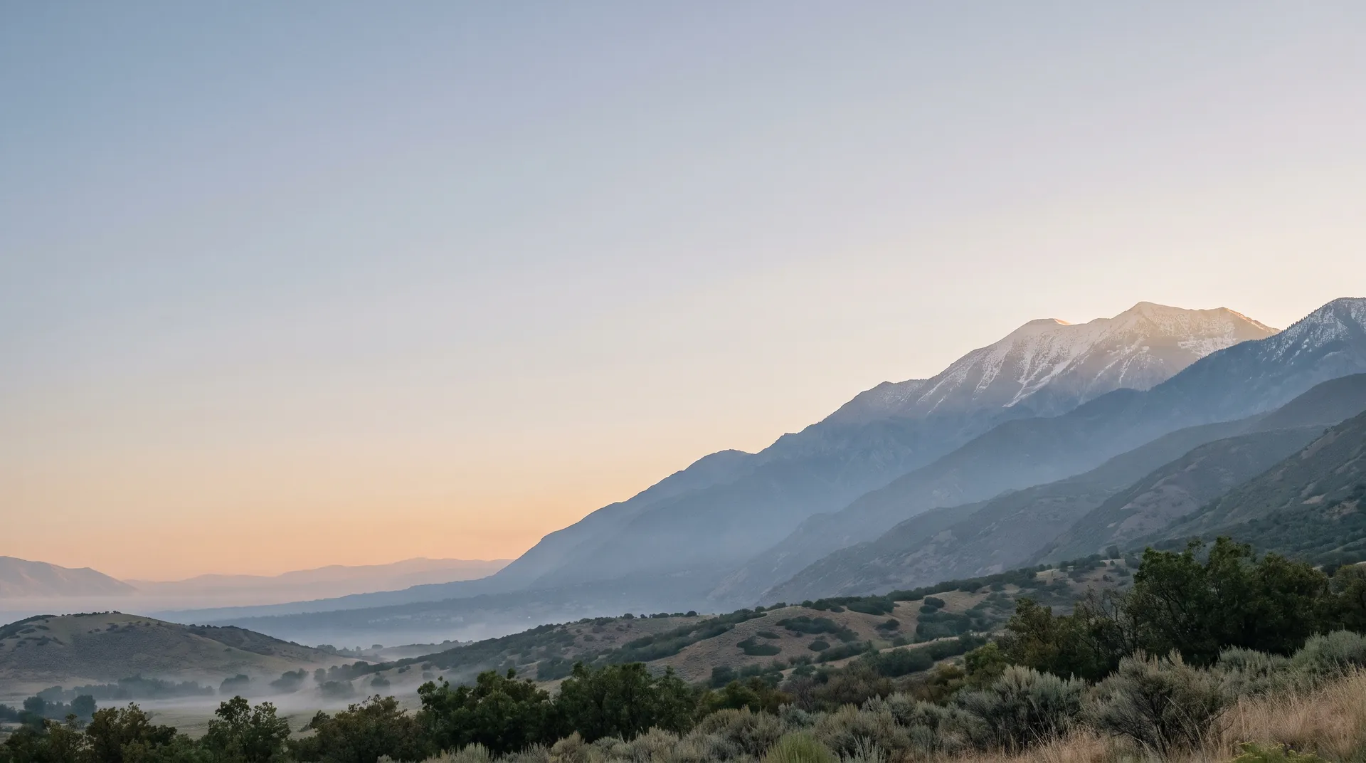 Dawn over the Wasatch Front, mist in the valley and snow on the peaks to the right